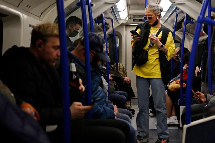 Passengers, some wearing protective face coverings and some not, travel during rush hour on the London Underground last month.