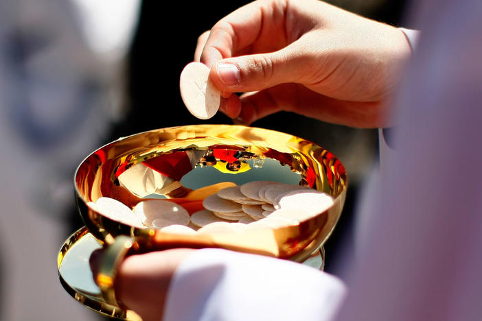 A priest holds a Holy Communion wafer in Washington, D.C.