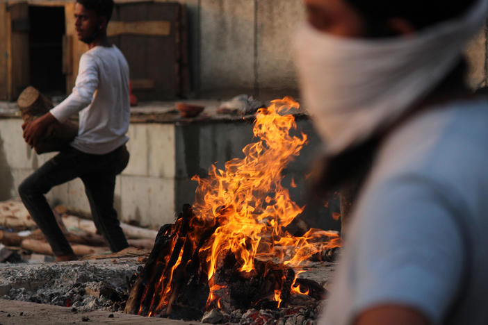 In New Delhi on Monday, family members cremate the body of a person who died after contracting COVID-19.