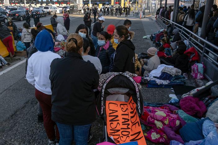 Migrants and asylum seekers are seen after spending the night in one of the car lanes off the San Ysidro Crossing Port on the Mexican side of the U.S.-Mexico border in Tijuana on April 24, 2021. A group of migrants asked U.S. migration authorities to allow them to start their migration process and decided to stay at the crossing port to pressure for a solution to their situation.