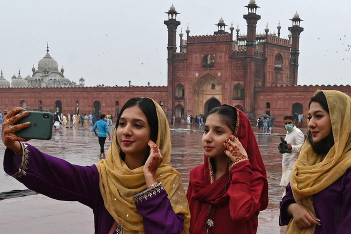 Muslim devotees takes a selfie using their mobile phones after offering special prayers at the historic Badshahi Mosque in Lahore, Pakistan.
