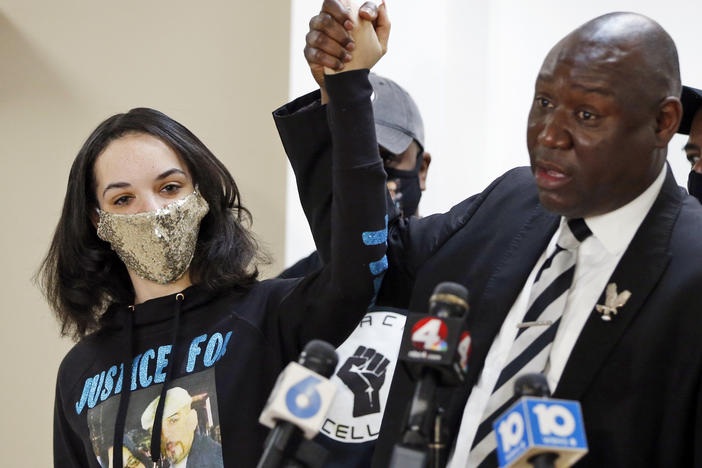 Karissa Hill, daughter of Andre Hill, raises hands with Benjamin Crump, the civil rights attorney representing Hill's family, at a news conference in February after former Columbus police officer Adam Coy was charged with murder in Hill's death.