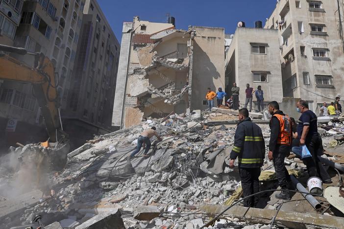 People search for victims under the rubble of a destroyed building in Gaza City's Rimal residential district on Sunday, following Israeli airstrikes.