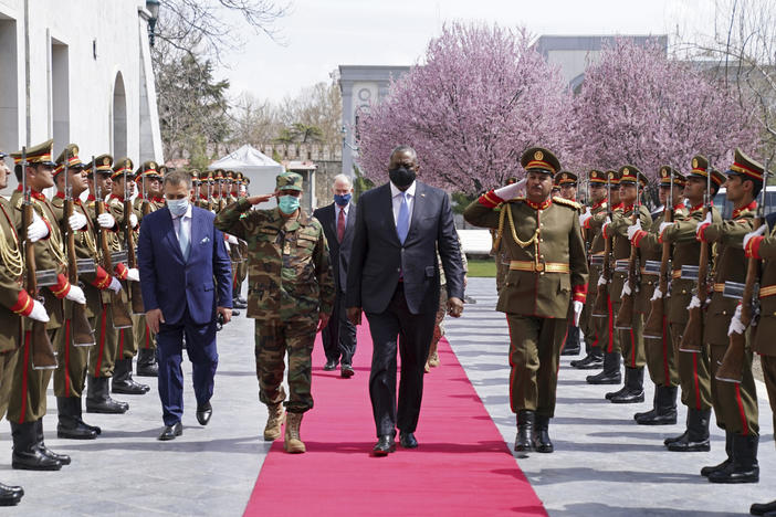 U.S. Defense Secretary Lloyd Austin (center) reviews an honor guard at Afghanistan's presidential palace in Kabul on March 21. President Biden says all U.S. troops will leave Afghanistan by September, though the Americans will still assist from "over the horizon."