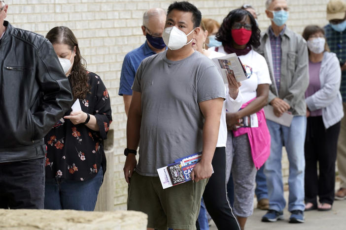 Voters are seen wearing masks in April as they prepared to cast ballots in Mansfield, Texas. The governor has now banned most state facilities from requiring masks.