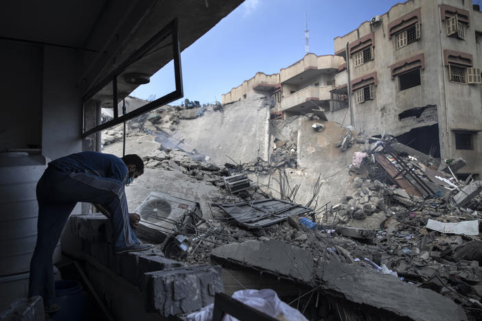 A Palestinian man inspects the damage of a six-story building destroyed by an early morning Israeli airstrike, in Gaza City on May 18, 2021.