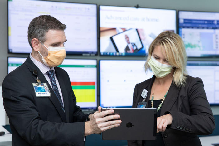 Dr. Michael Maniaci and Dr. Margaret Paulson confer at the Mayo Clinic's hospital-at-home command center in Jacksonville, Florida.