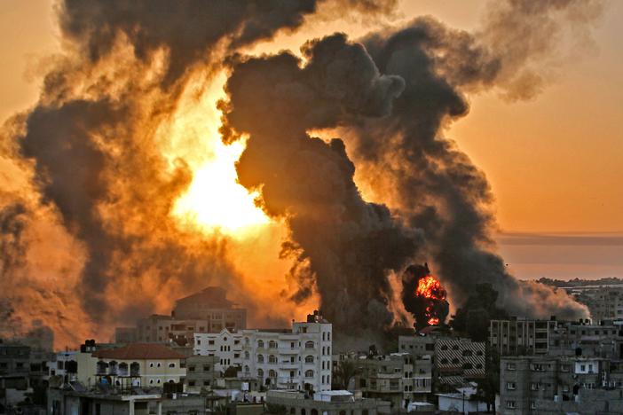 A fire rages at sunrise in the city of Khan Yunis following an Israeli airstrike in the southern Gaza Strip early on May 12.