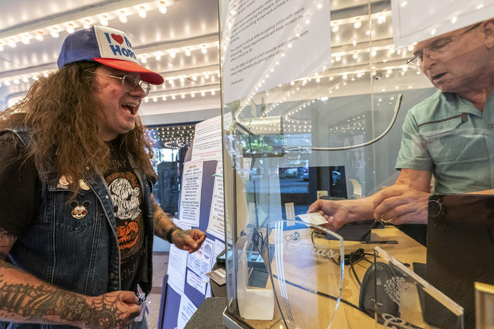 Darren Ford (left) reacts to the new mask guideline while presenting his vaccine card at Liberty Theatre on May 14 in Camas, Wash. Gov. Jay Inslee announced last Thursday that the statewide mask mandate would no longer apply to fully vaccinated adults.
