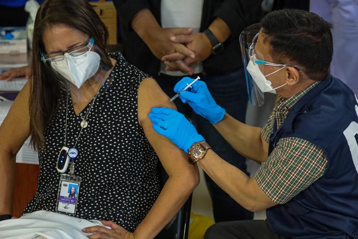 Philippines Health Secretary Francisco Duque III administers the China-made Sinovac COVID-19 vaccine to Eileen Aniceto, a doctor at the Lung Center of the Philippines.