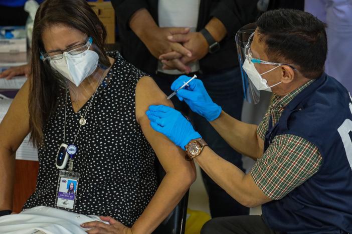 Philippines Health Secretary Francisco Duque III administers the China-made Sinovac COVID-19 vaccine to Eileen Aniceto, a doctor at the Lung Center of the Philippines.
