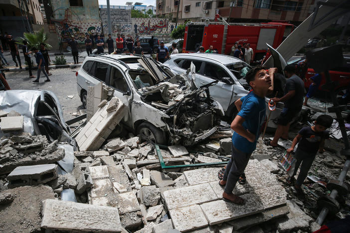 Young Palestinians inspect the damage an Israeli attack inflicted on houses in the Sabra neighborhood of Gaza City. A man who lives in the middle of the Gaza Strip says his family is traumatized by the violence.