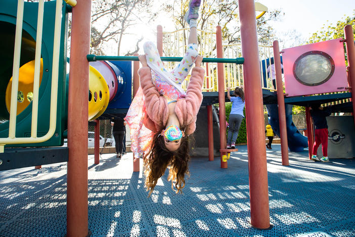 A student wears a mask while swinging around with her kindergarten class this month at Kenter Canyon School in Los Angeles.