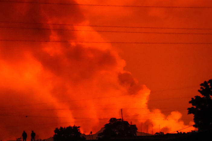 Two people are seen silhouetted against a night sky turned red by the eruption of Congo's Mount Nyiragongo on Saturday.