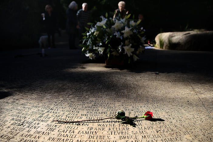 A flower lays on the engraved names of AIDS victims at the National AIDS Memorial Grove on December 1, 2015 in San Francisco, Calif.