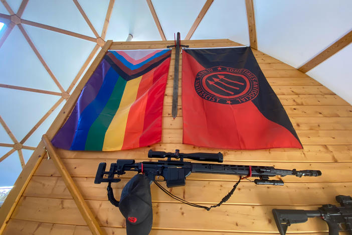 Various guns and flags adorn the wall leading up to the ranch house's second floor.
