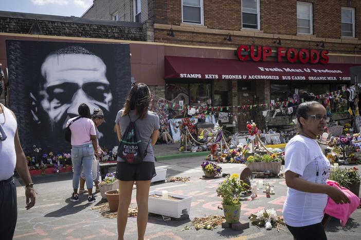 People walk through George Floyd Square on the anniversary of George Floyd's death in Minneapolis, Minn.