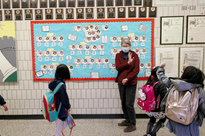 Students wave goodbye during dismissal at Yung Wing School P.S. 124 on March 25, 2021 in New York City.