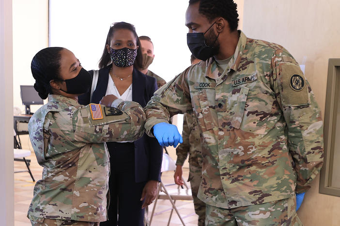 Nearly 130 million U.S. adults have completed their vaccine regimens, the CDC says, with another 70 million vaccine doses currently in the distribution pipeline. Here, Maryland National Guard Brig. Gen. Janeen Birckhead greets soldiers last week at a mobile vaccine clinic in Wheaton, Md.
