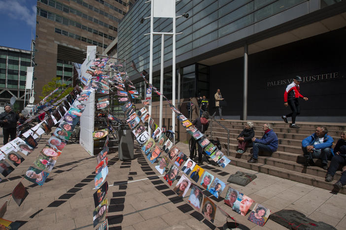 Pictures of plaintiffs fly outside the court in The Hague, Netherlands, before Wednesday's ruling ordering Royal Dutch Shell to rein in its carbon emissions. Thousands of citizens joined the suit charging that Shell's fossil fuel investments endanger lives.