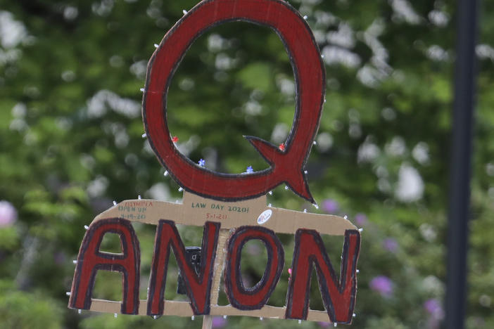 A person carries a sign supporting QAnon during a May 2020 protest rally in Olympia, Wash.