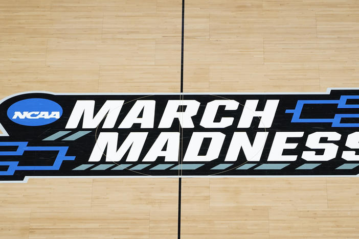 The March Madness logo is seen during a men's college basketball NCAA tournament game in Indianapolis. The Supreme Court has eroded<strong> </strong>the difference between elite college athletes and professional sports stars.