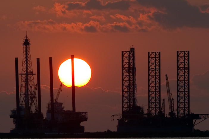 The energy industry was shaken by a trio of events this week that could help shape the future of oil and gas. Here, the sun sets behind two under-construction offshore oil platform rigs in Port Fourchon, La., in 2010.