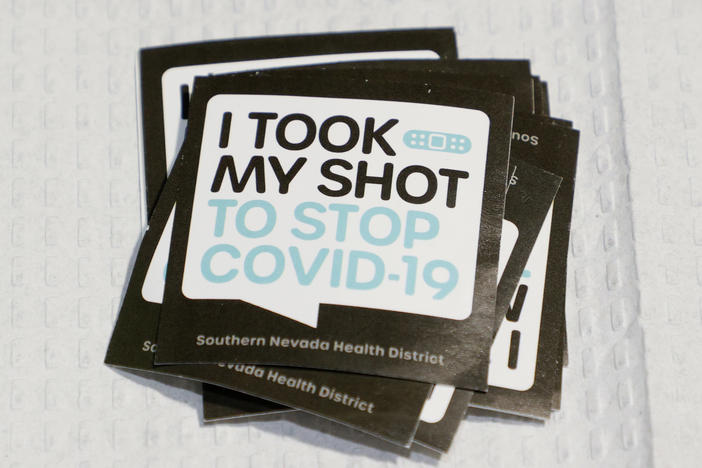 Stickers are stacked up for people receiving vaccinations at a pop-up COVID-19 vaccination clinic in Las Vegas on May 21. As countries open their doors to travelers again, there is confusion about how people will prove their vaccination status.
