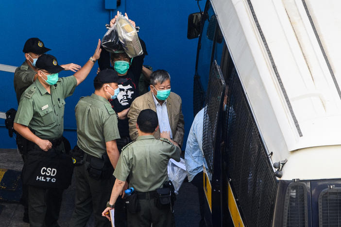 Pro-democracy activists Leung Kwok-hung (center) and Lee Cheuk-yan head to a Hong Kong Correctional Services van Friday before their sentencing hearing. Both received three years in prison for organizing and attending a protest on China's National Day on Oct. 1, 2019.