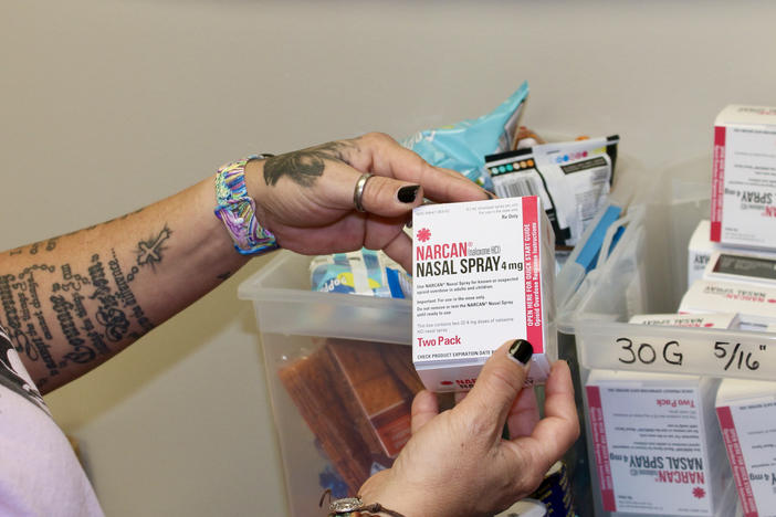 Kelly Hans holds a box of Narcan nasal spray at the county's One-Stop Shop in Austin.