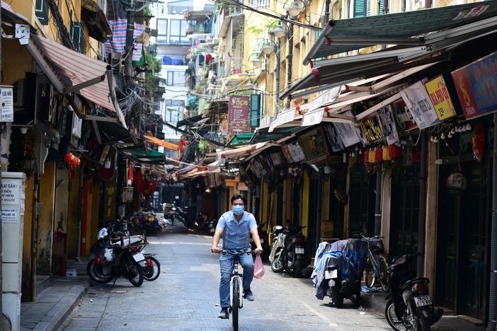 A man rides a bicycle on an empty street amid lockdown restrictions due to a surge in COVID-19 cases in Hanoi on May 10. On Saturday, Vietnam's health ministry announced the discovery of a new coronavirus variant in the country.