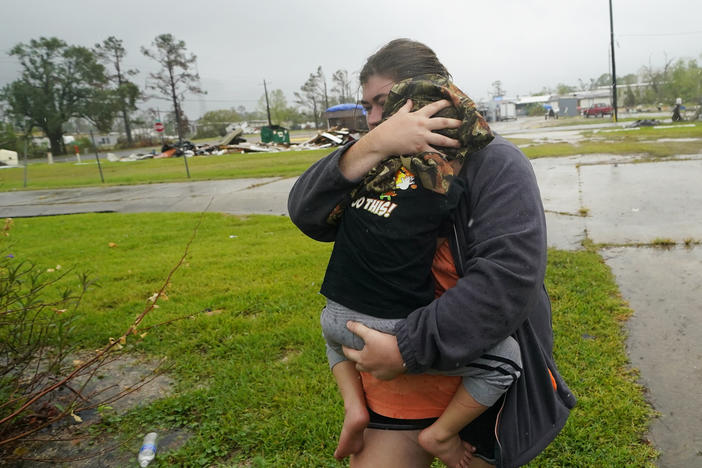 Danielle Fontenot runs to a relative's home in the rain with her son, Hunter, ahead of Hurricane Delta in Lake Charles, La., last October. The 2021 Atlantic hurricane season began June 1.