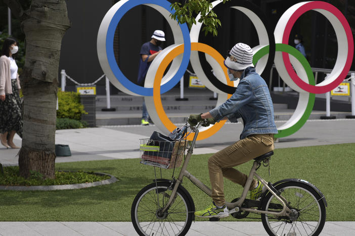 A bicyclist rides past the Olympic rings on Wednesday in Tokyo, where the Olympics are scheduled to kick off on July 23.