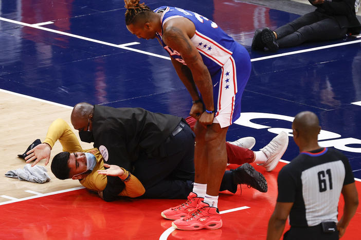 Dwight Howard of the Philadelphia 76ers looks down at a fan who ran onto the court and was tackled by security in Game 4 of the Eastern Conference first-round series against the Washington Wizards on Monday.