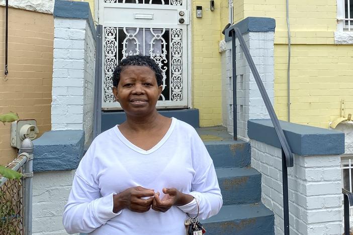 Katherine Gaines stands in front of her childhood home in Washington, D.C. She moved back in two years ago to help care for her mother, who has Alzheimer's disease.