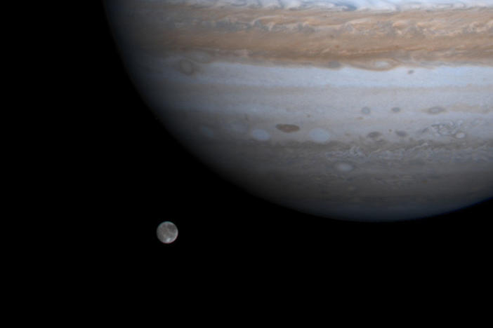 The solar system's largest moon, Ganymede, is pictured with Jupiter in a photo by NASA's Cassini spacecraft on Dec. 3, 2000. NASA's Juno mission got close to Ganymede on Monday.