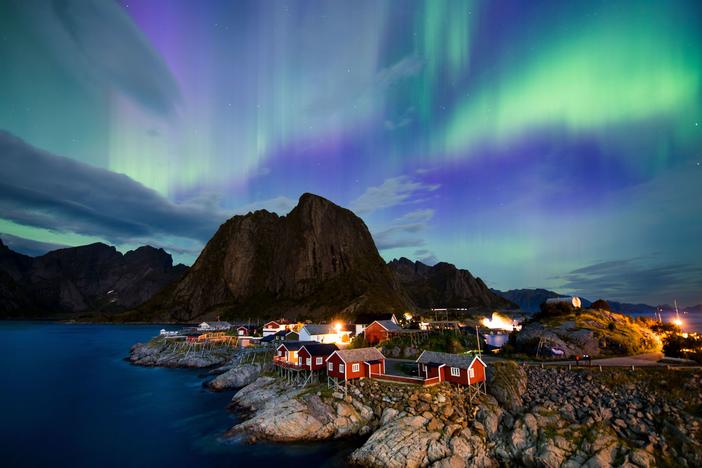 The northern lights (aurora borealis) illuminate the sky over Reinfjorden in Reine, on Lofoten Islands in the Arctic Circle in 2017.