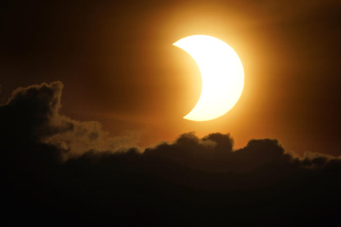 The sun is partially eclipsed as it rises over lower Manhattan in New York on Thursday.