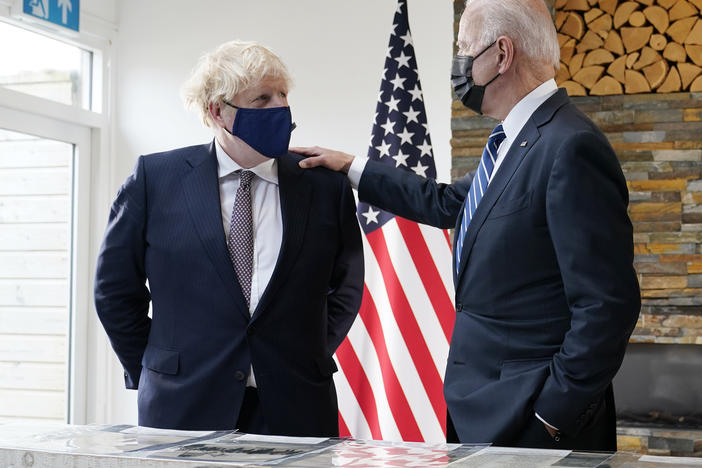 British Prime Minister Boris Johnson and President Biden talk Thursday during a meeting in Carbis Bay, England, as they look over copies of the original Atlantic Charter from 1941.