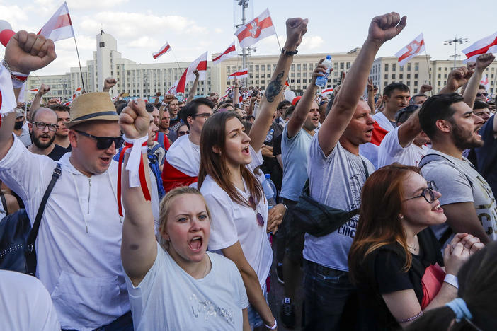 People with old Belarusian national flags shout during an opposition rally in August in Minsk, Belarus.