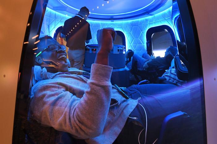 Participants sit a Blue Origin space simulator during a conference on robotics and artificial intelligence in Las Vegas on June 5, 2019. On Saturday, Blue Origin announced that an unidentified bidder will pay $28 million for a suborbital flight on the company's New Shepard vehicle.