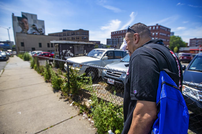 Will wipes away sweat on a hot day while walking down Willow Street in Lynn, Mass., as he looks to distribute safety supplies to drug users on the street.