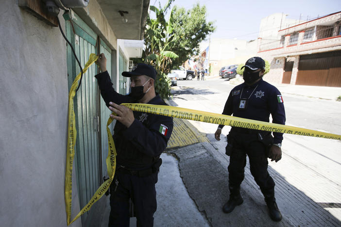 Police mark a security perimeter around the house where bones were found under the floor in the Atizapan municipality of the State of Mexico, on May 20, 2021. Police have turned up bones and other evidence under the floor of the house where a man was arrested for allegedly stabbing a woman to death and hacking up her body.