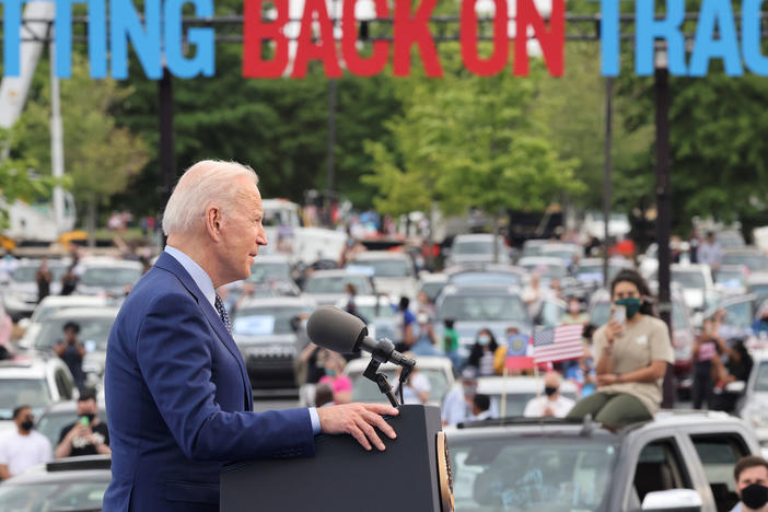 President Joe Biden speaks during the Democratic National Committee's "Back on Track" drive-in car rally in Duluth, Georgia, to celebrate his 100th day in office. Immigrant advocates were there to protest.