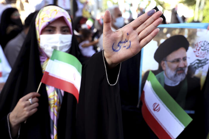 A supporter of presidential candidate Ebrahim Raisi shows her hand with writing in Persian that reads "Raisi," during a rally in Tehran, Iran, Wednesday. He is the country's hard-line judiciary chief and is closely aligned with Supreme Leader Ayatollah Ali Khamenei.