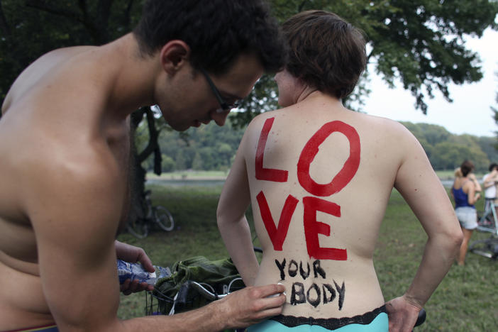 On Sunday, Sept. 4, 2011 Cheryl Rehmann has a message painted on her back by Matthew Wellstein before the start of the annual Naked Bike Ride in Philadelphia.