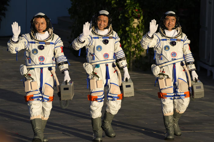 Chinese astronauts, from left, Tang Hongbo, Nie Haisheng, and Liu Boming wave as they prepare to board for liftoff Thursday at the Jiuquan Satellite Launch Center in Jiuquan in northwestern China. China plans to launch three astronauts onboard the Shenzhou-12 spaceship who will be the first crew members to live on China's new orbiting space station Tianhe, or Heavenly Harmony.