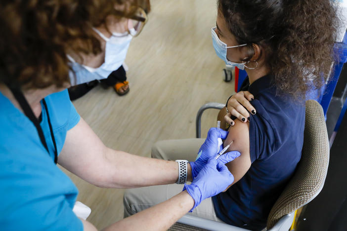 A teen gets a dose of Pfizer's COVID-19 vaccine last month at Holtz Children's Hospital in Miami. Nearly 7 million U.S. teens and preteens (ages 12 through 17) have received at least one dose of a COVID-19 vaccine so far, the CDC says.