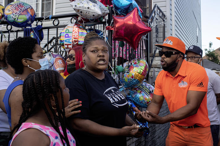 Shanduke McPhatter, a non-violence activist, talks to a woman who recently lost a relative to gun violence. The peace vigil took place on the block where 10-year-old Justin Wallace was shot to death.