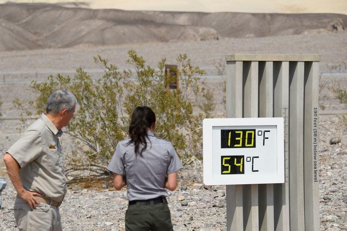 Visitors feel the heat in California's Death Valley earlier this week. This record-setting heat wave's remarkable power, reach and unusually early appearance is giving meteorologists yet more cause for concern about extreme weather in an era of climate change.